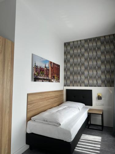 una camera da letto con un letto e un quadro sul muro di Dias Apartment a Pinneberg