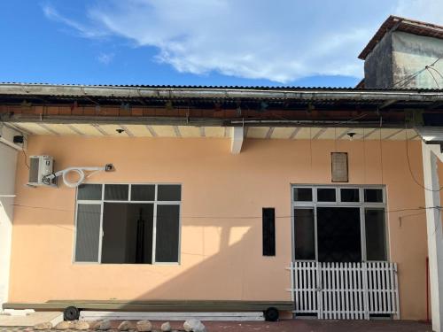a house with two windows and a white fence at Casa simples e conforto in Belém