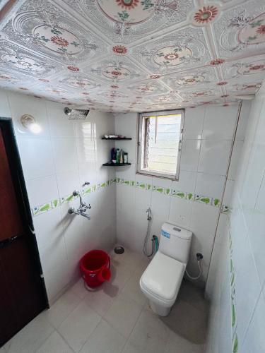 ein Badezimmer mit Toilette und einer Decke mit Blumen in der Unterkunft Getgo Stays in Camorlim