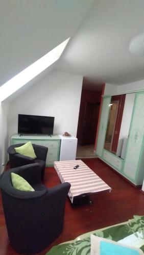 a living room with two chairs and a table at Šestajovický pivovar ubytování in Šestajovice