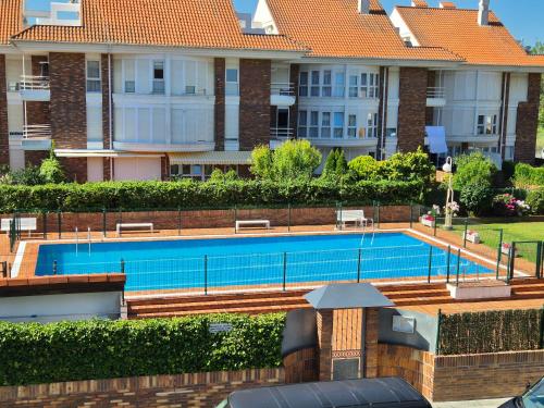a swimming pool in front of a large building at Apto en la playa Santoña C05A02 in Santoña
