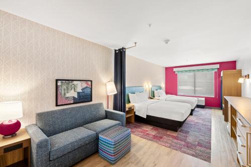 une chambre d'hôtel avec un lit et un canapé dans l'établissement Home2 Suites By Hilton Riverside Downtown, à Riverside