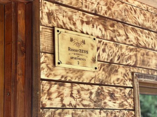 a sign on the side of a wooden wall at Resort Komovi in Kravlja