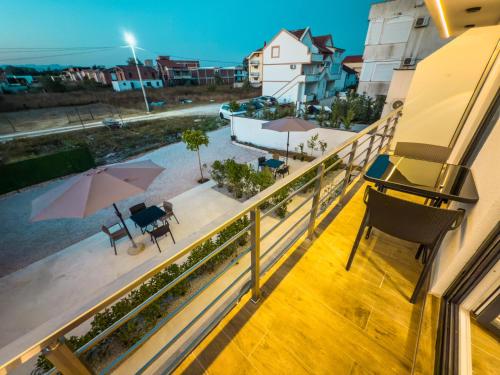 a balcony with a view of a pool and umbrella at TaNa's Apartments in Donji Štoj