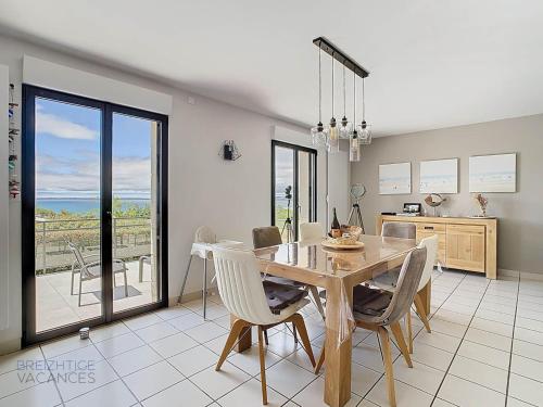une cuisine et une salle à manger avec une table et des chaises dans l'établissement Maison de Porz Iroise (Vue Mer), à Plomodiern