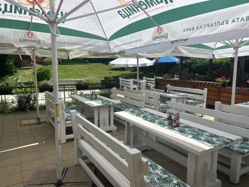 a group of white tables and chairs under an umbrella at Complex Popangelov in Borovets