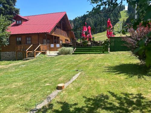 a log cabin with two people standing in the yard at Complex Popangelov in Borovets