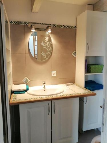 une salle de bain avec un lavabo et un miroir dans l'établissement la bastide aux buis avec piscine, à Blauvac