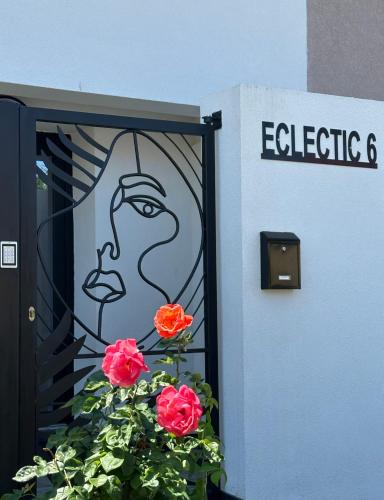 a door with a painting of a face and two roses at Eclectic 6 in Satu Mare