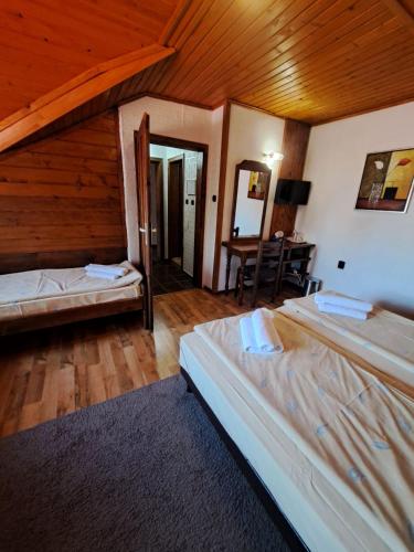 a bedroom with two beds and a wooden ceiling at Complex Popangelov in Borovets