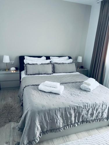 a bedroom with a bed with two towels on it at City Nest Apartament in Rădăuţi