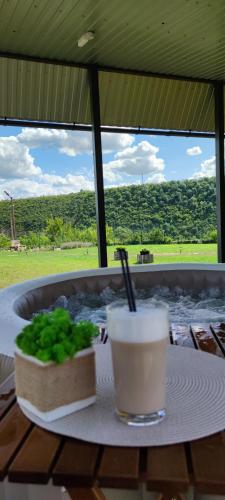 a plate with a drink and a bowl of greens on a table at ILLU Resort in Orhei