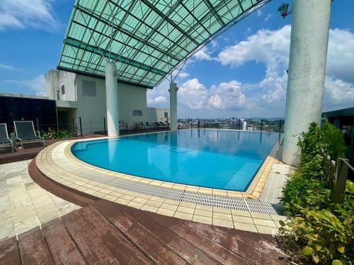 a large swimming pool in a building with a glass roof at Deluxe Room for 2 Pax - Central of Kuching in Kuching