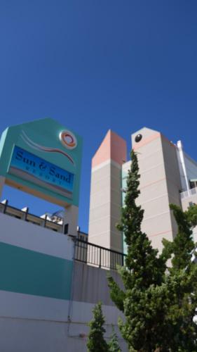 a building with a sign on the side of it at Sun & Sand Resort Oceanfront Suites in Virginia Beach