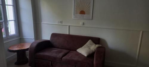 a brown leather chair with a pillow on it in a room at Au Bonheur du Puy in Moutiers-sur-le-Lay