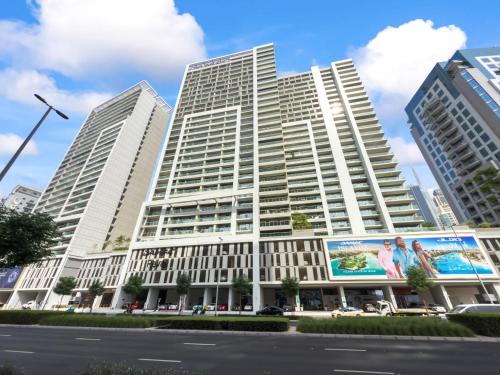 a tall white building with a billboard in front of it at Burj khalifa and Canal views - Luxury Apartments for Rent in Dubai Business Bay in Dubai