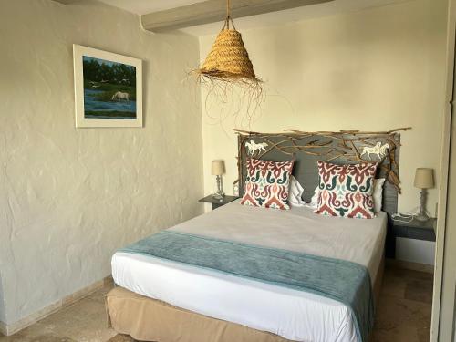 a bedroom with a bed with pillows on it at Hotel Mas Des Barres in Saintes-Maries-de-la-Mer