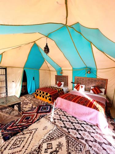 a tent with two beds in a room at Alan Tent Merzouga in Merzouga