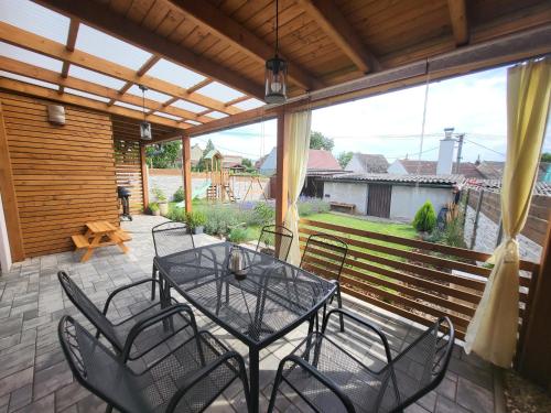 a patio with a glass table and chairs on it at Ubytování Ve dvorku in Uherčice