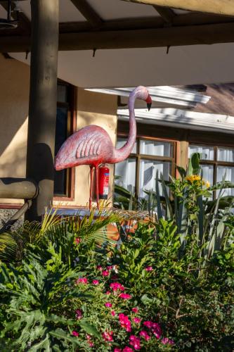 a statue of a pink flamingo in a garden at Naivasha Crescent Lodge in Naivasha