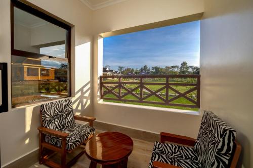 a room with two chairs and a large window at Naivasha Crescent Lodge in Naivasha