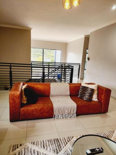 a brown couch sitting in a living room at Eastern Road Executive Suites in Harare