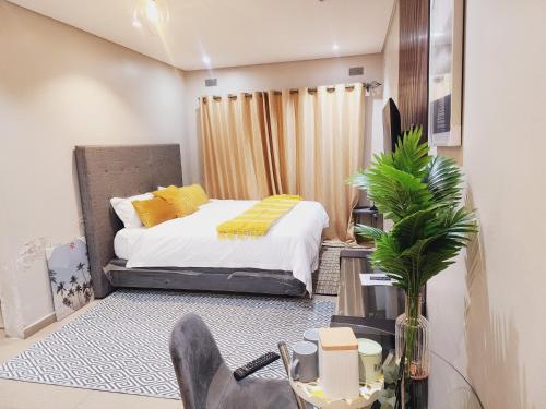 a bedroom with a bed with yellow pillows on it at Eastern Road Executive Suites in Harare