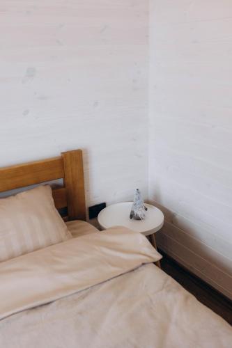 a bedroom with two beds and a small table at Райське містечко «Акваторія» in Perlivka