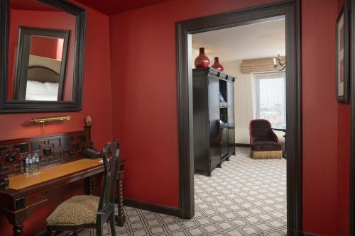 a red room with a desk and a mirror at Hotel Des Indes The Hague in The Hague