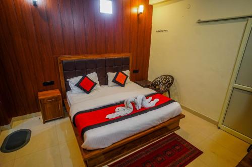 a bedroom with a bed with two towels on it at THE Grahil Hotel & Restaurant !Awarded Hotel ! BALCONY ROOMS With BEST Valley View Roof top Cafe ! Near JW Marriott Mussoorie in Mussoorie
