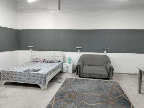 a bedroom with two beds and a chair in it at Aerodrom Hotel in Almaty