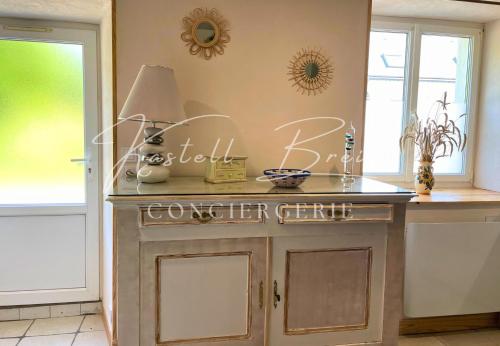 a kitchen with a table with a sign on the wall at Gîte Le Lojou in Le Merzer