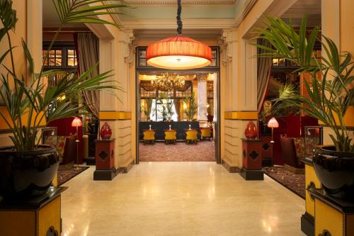 a lobby with potted plants and a chandelier at Hotel Des Indes The Hague in The Hague