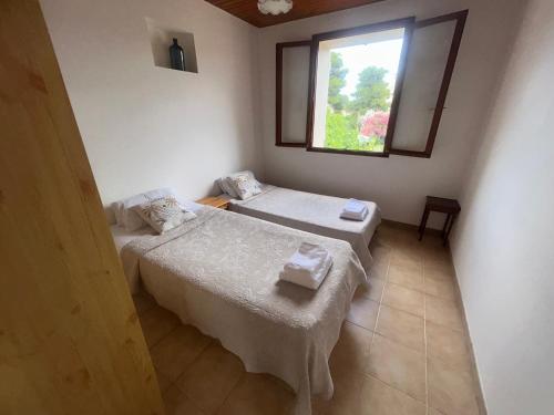 una habitación con dos camas y una ventana en T3 à 100m de la plage, au calme, Saint-Florent, en Saint-Florent