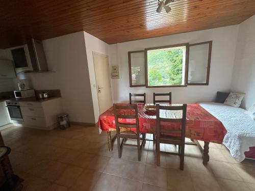 Un dormitorio con una mesa y una cama y una ventana. en T3 à 100m de la plage, au calme, Saint-Florent, en Saint-Florent