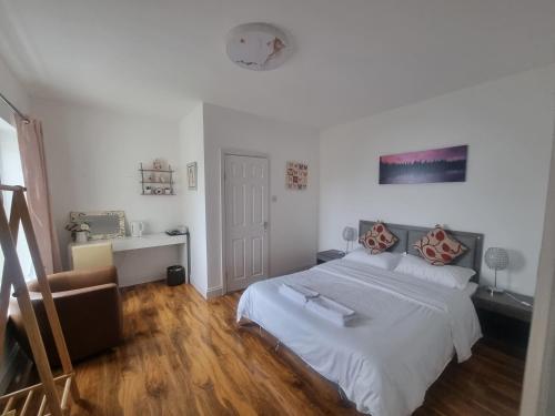 a white bedroom with a bed and a chair at Comfy Rooms Close to Airport in NWI