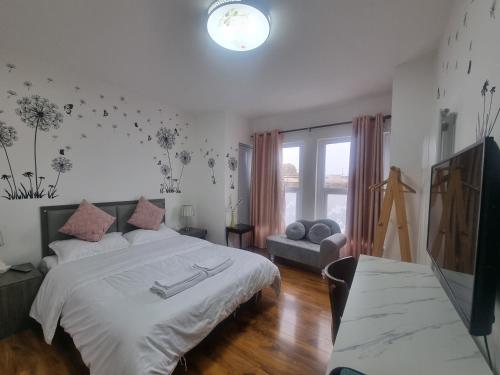 a bedroom with a large white bed and a couch at Comfy Rooms Close to Airport in NWI