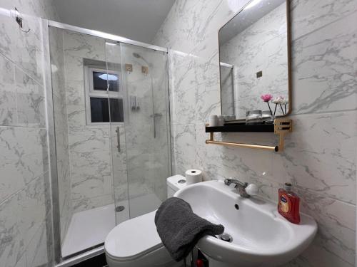 a white bathroom with a sink and a shower at Comfy Rooms Close to Airport in NWI