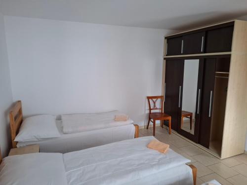 a room with three beds and a chair and a window at Parťákova Hasičárna & Penzion in Hradec Králové