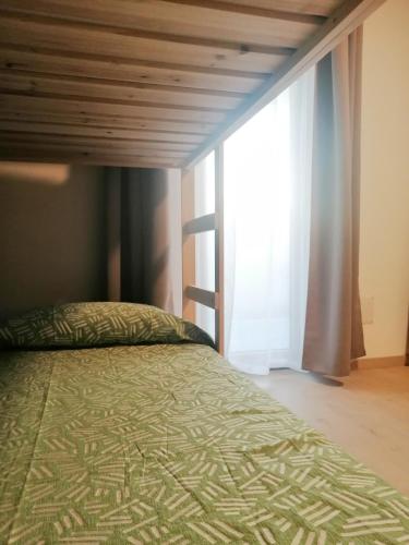 a bedroom with a bed and a large window at La Casa di Legno in Tortolì