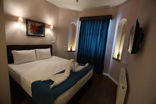 a small bedroom with a bed with a blue seat at Grand Uchisar Hotel in Uchisar