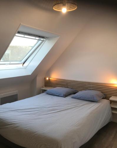 une chambre avec un grand lit avec une fenêtre dans l'établissement Villa Fouesnant Beg Meil Ty Bigorn 150 m plage et sentiers, à Fouesnant