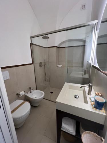 a bathroom with a toilet and a sink and a shower at PALAZZO SAN ROCCO in Sperlonga