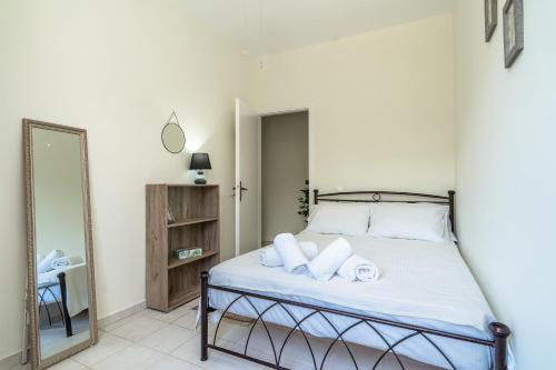 a bedroom with a bed with white sheets and a mirror at Iri's Place in Mavráta