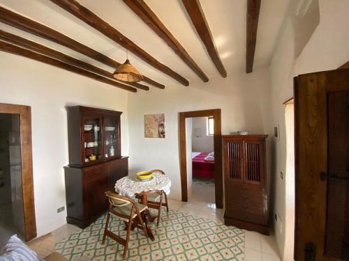 a living room with a table and a bedroom at Traditional Eolian House Luna - Unique experience in San Salvatore