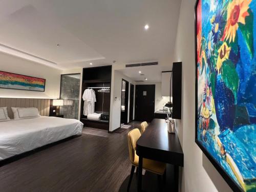 a hotel room with a bed and a desk and a bedroom at The Saphire Palace by Anna Vũ in Ha Long
