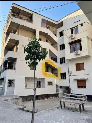 ポグラデツにあるApartament pushim pogradecの前に木がある白い建物