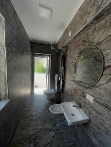 ポグラデツにあるApartament pushim pogradecの洗面台、鏡、トイレ付きのバスルーム