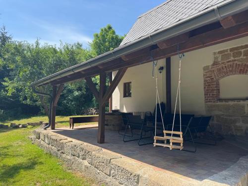 a pavilion with chairs and a bench on a patio at V Údolí in Jablonné v Podještědí
