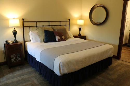 a bedroom with a large bed with two lamps and a mirror at Landoll's Mohican Castle in Loudonville